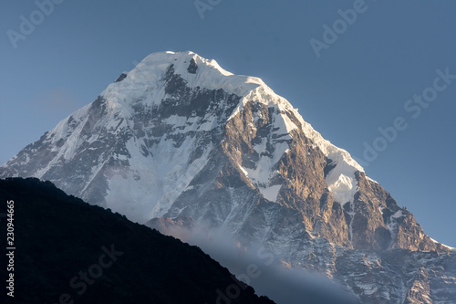 Hiunchuli snowcapped mountain summit against blue sky in Annapurna Range, Himalayas photo