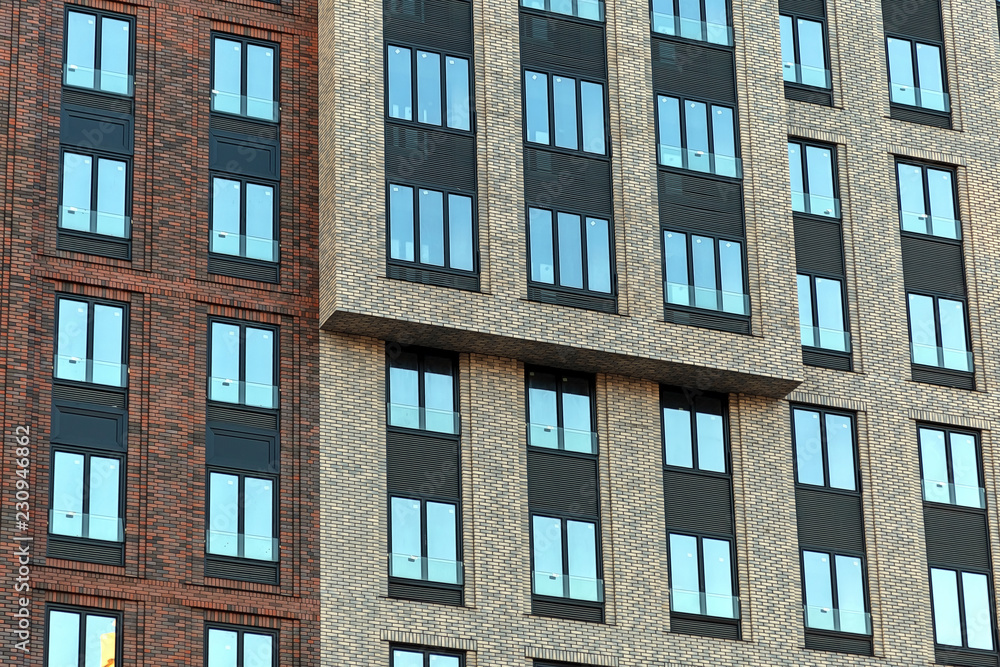 Colorful Brick wall of a skyscraper with windows.