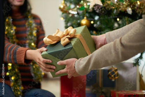 Hands of couple exchanging presents on Christmas eve