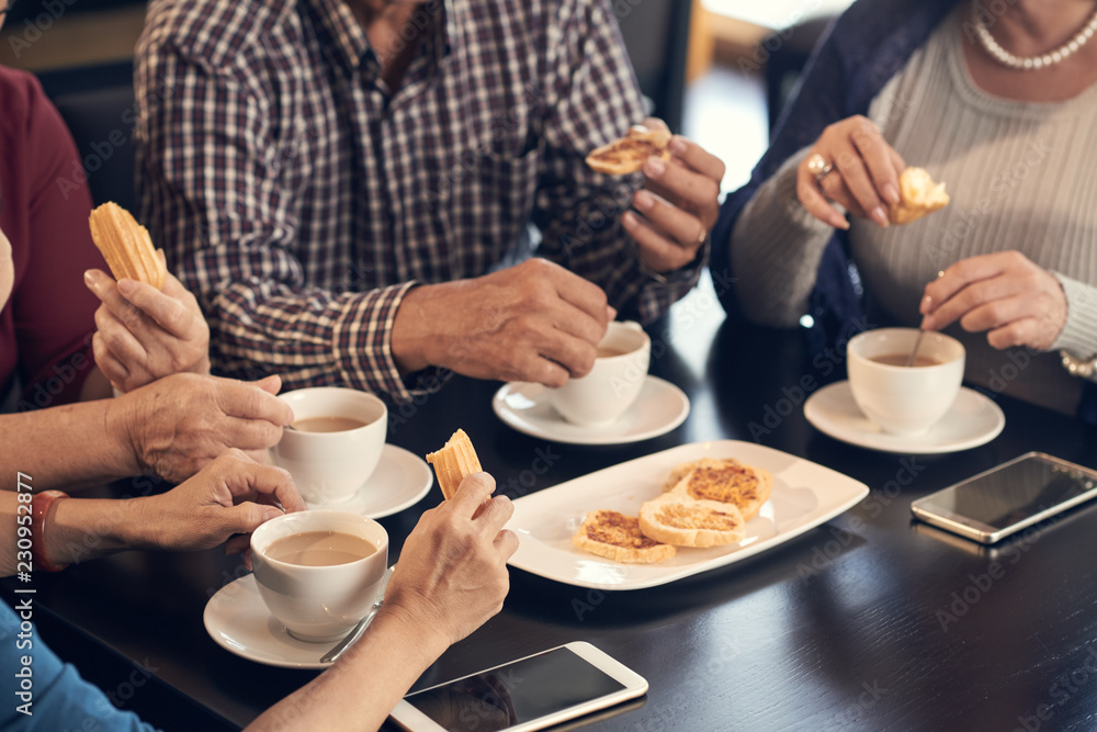 Cropped image of seniors having coffee and cookies for breakfast Cropped image of seniors having coffee and cookies for breakfast