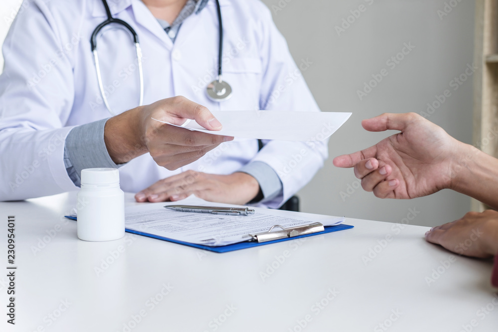Doctor filling up an history form while consulting to patient and recommend treatment methods and how to rehabilitate Doctor filling up an history form while consulting to patient and recommend treatment methods and how to rehabilitate