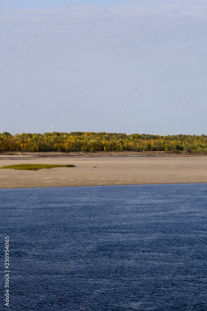 A natural blurred landscape of the river in autumn. Astrakhan Region, Russia. Defocused.River sand beach. A natural blurred landscape of the river in autumn. Astrakhan Region, Russia. Defocused.River sand beach.