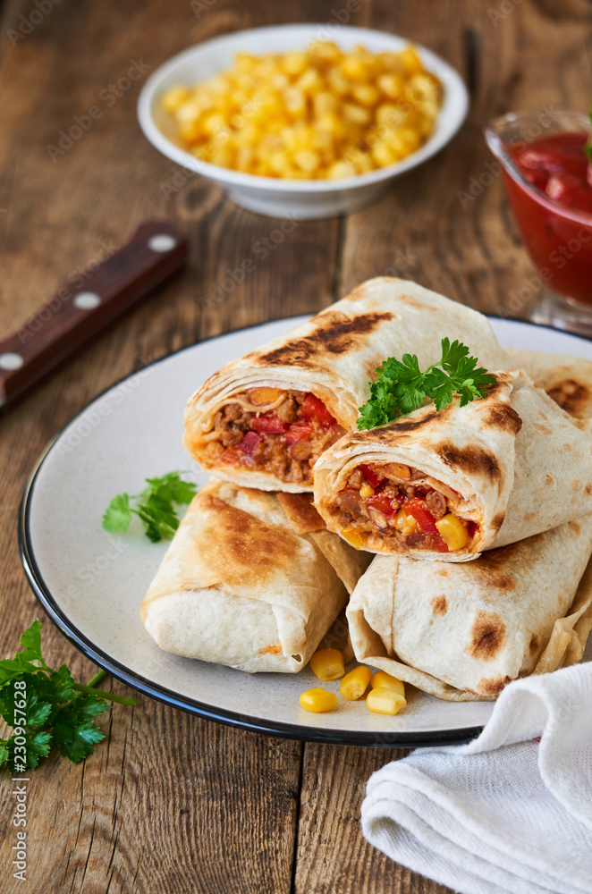 Burrito with ground beef and vegetables on a plate