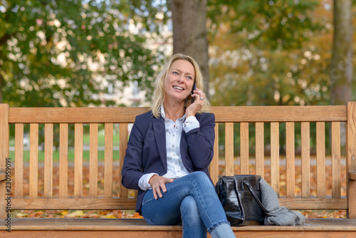 Attractive middle aged blond woman on a bench © michaelheim
