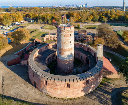 Medieval Wisloujscie Fortress with old lighthouse tower in port of Gdansk, Poland. A unique monument of the fortification works. Aerial view at sunset. Exterior Northern  Gdansk port in the background photo