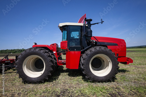 heavy red tractor at agricultural exhibition in motion