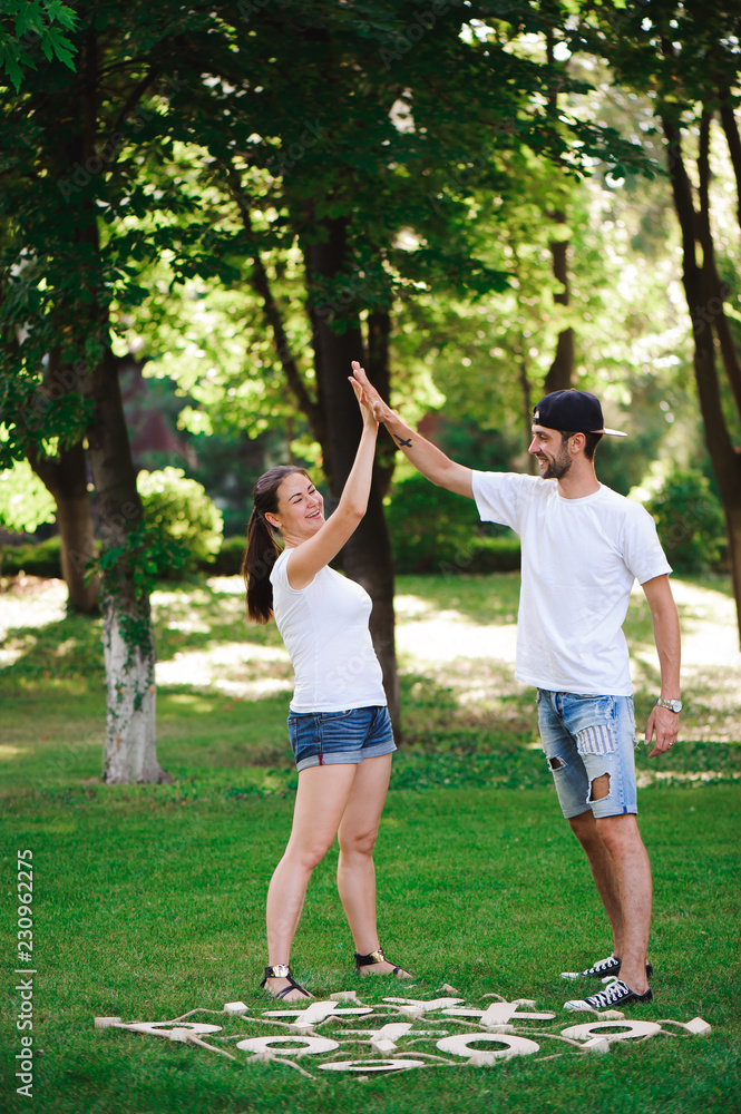 A young couple celebrate victory playing tic-tac-toe in the park A young couple celebrate victory playing tic-tac-toe in the park