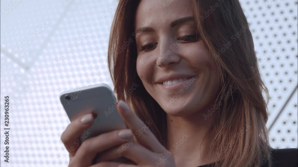 Close-up potrait happy and in love girl typing in the phone and smile Close-up potrait happy and in love girl typing in the phone and smile