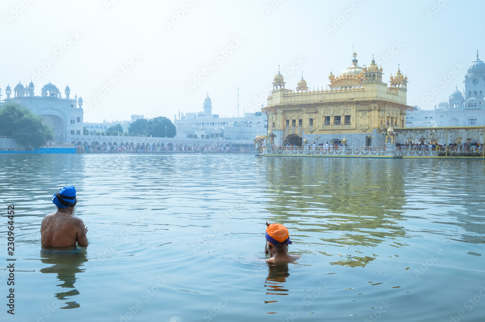 Unidentifiable Punjabi Sikh pilgrim devotee "Nihang Warrior" taking bath and prayer in pond and