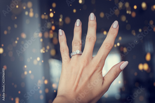 Diamond ring on a finger.
