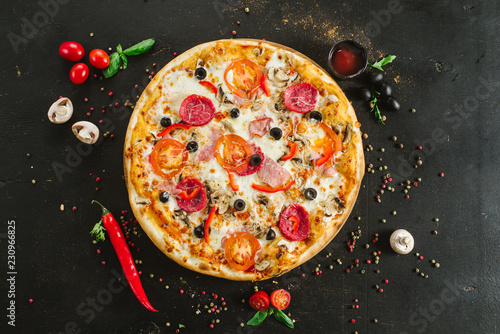 Delicious classic meat pizza on black background