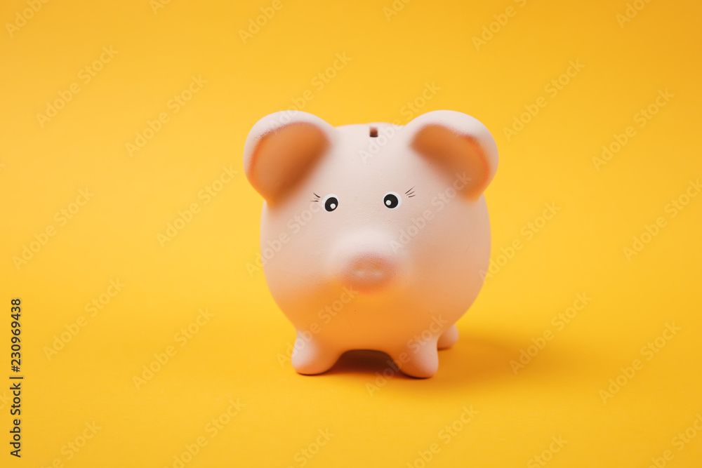 Close up photo of pink piggy money bank isolated on bright yellow wall background. Money accumulation, investment, banking or business services, wealth concept. Copy space advertising mock up.