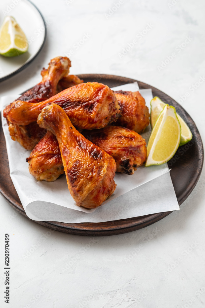 Chicken legs with sauce, rosemary and lime on a white background. Copy space.