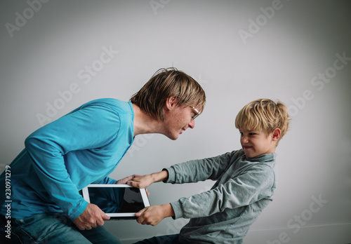 computer addiction- father taking touch pad from angry child