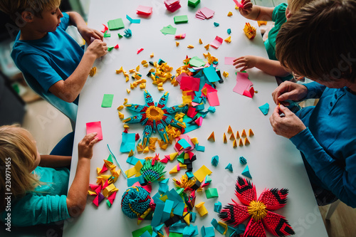 teacher and kids making origami crafts with paper photo