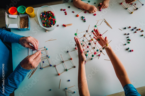 teacher and kids making geometric shapes from sticks and play dough