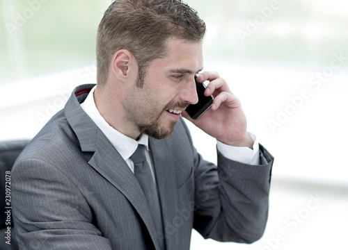 closeup.businessman working on laptop and talking on the phone