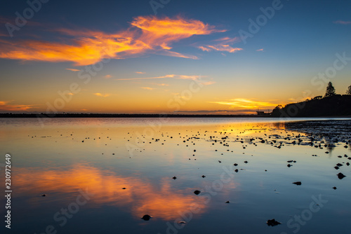 Sunset and reflection over still water at Harrington, Australia