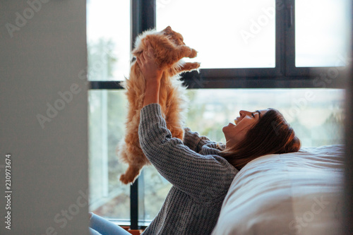 woman playing games with her cat at home