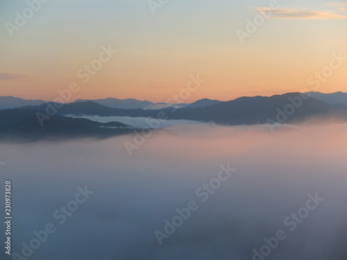Sunrise at hill in the morning with mist below © Pirun