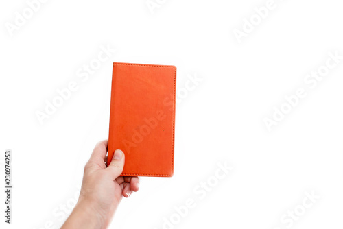Female hand holding an orange notebook. Educational concept, school, back to school, everyday notes, notepad. photo