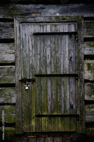 Cuadro en lienzo Aged locked wooden door of a gloomy abandoned house (like in horror movies or in