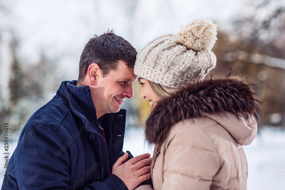 Family, winter holidays, Christmas and people concept – Romantic couple is having fun outdoors in winter. Family, winter holidays, Christmas and people concept – Romantic couple is having fun outdoors in winter.