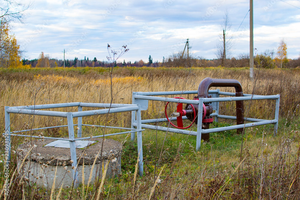 Pipe and a red valve pipe near oil pump jacks.