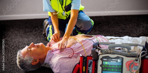 Paramedic using an external defibrillator on an unconscious photo