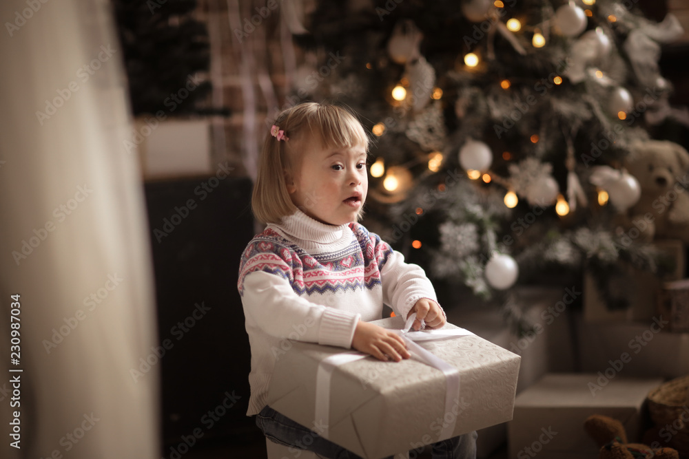 Toddler with Down syndrome, gift Christmas tree Toddler with Down syndrome, gift Christmas tree