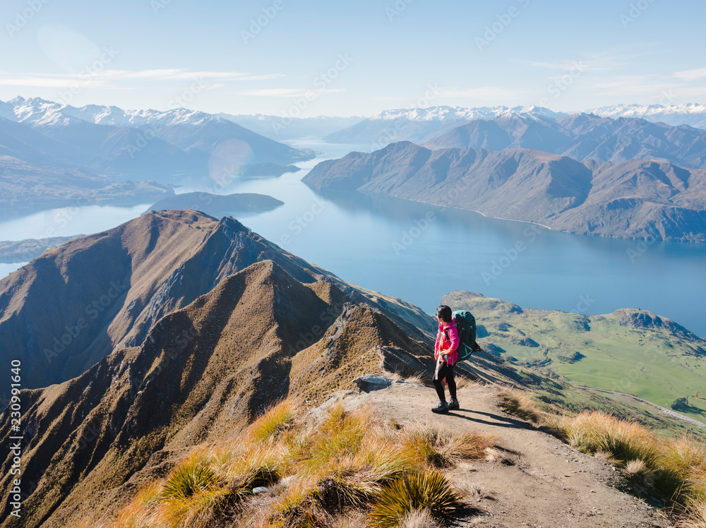 Woman hiker enjoying the view from the Roys Peak trail near Wanaka, Otago, South Island, New Zealand Woman hiker enjoying the view from the Roys Peak trail near Wanaka, Otago, South Island, New Zealand