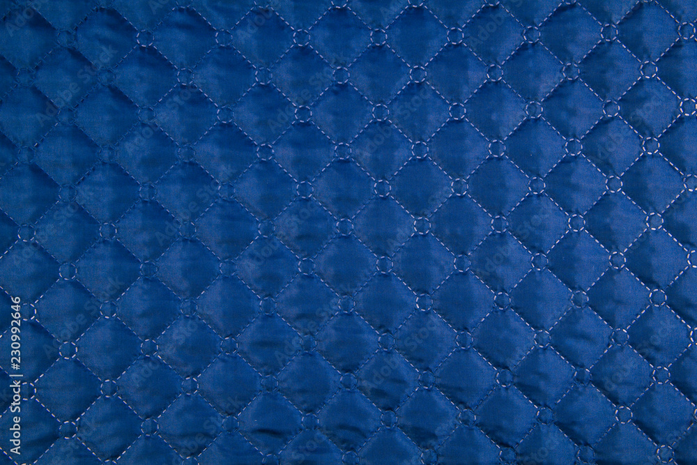 Blue quilted fabric. The texture of the blanket. Stock Photo