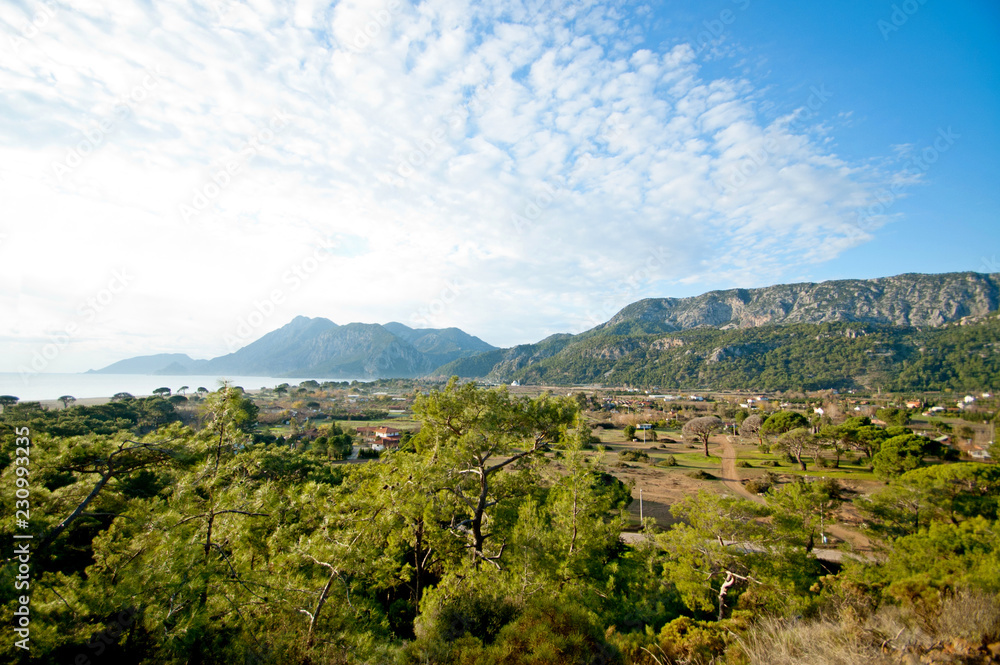 Obraz premium Scenic view of the mountains, sea and forest taken on a bright sunny day