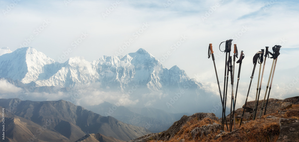 Trekking sticks on background mountains range. Panoramic view. - obrazy, fototapety, plakaty 