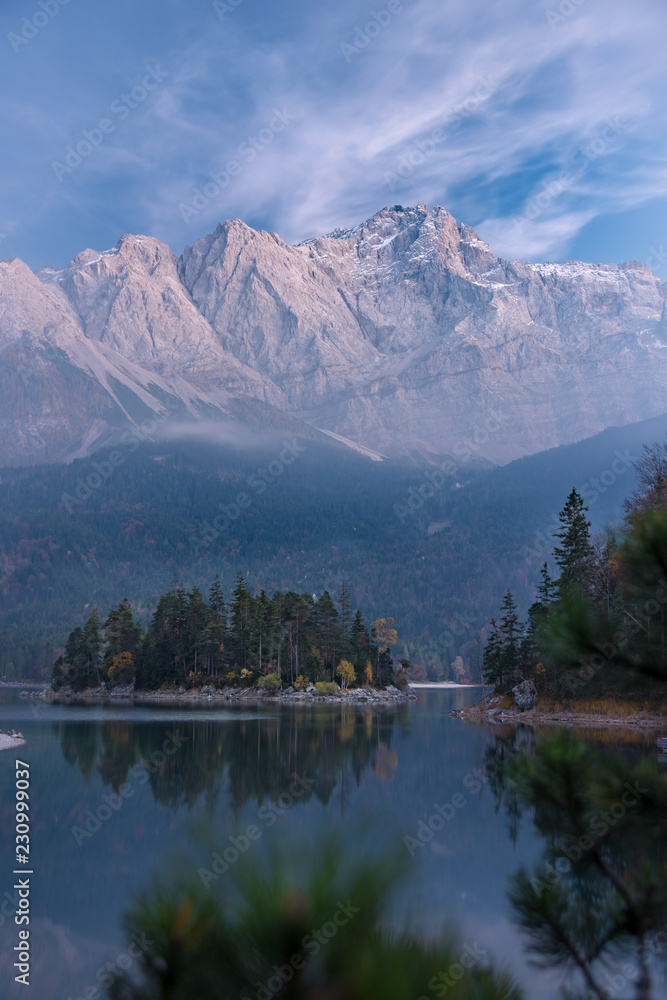 Spiegelung der Zugspitze und des Herbstwalds im glasklaren Eibsee