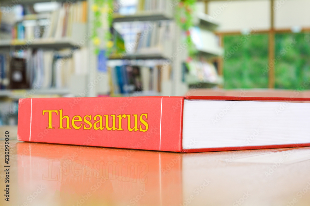 Thesaurus textbook, book on wood table, blur abstract campus school