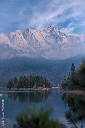 Spiegelung der Zugspitze und des Herbstwalds im glasklaren Eibsee