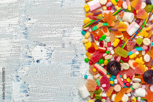 Colorful candies on wooden table background.