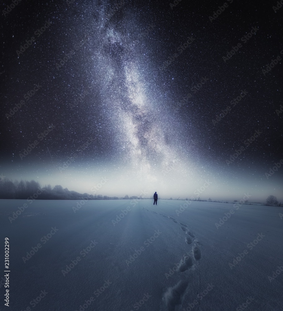 Starry night sky and man silhouette standing on snow - obrazy, fototapety, plakaty 
