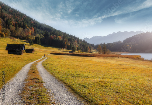 Incredible Bavarian Alps. View on Fairy Alpine valley with Tipical wooden huts, with Zugspitze mountain range at sunset. colorful sky under sunlight over meadow. Geroldsee. Bavavia. Germany. Europe photo