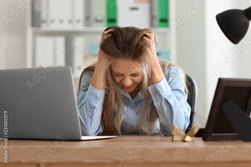 Stressed young woman at wor...