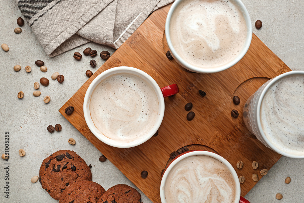 Cups with tasty aromatic coffee and cookies on grey table Cups with tasty aromatic coffee and cookies on grey table
