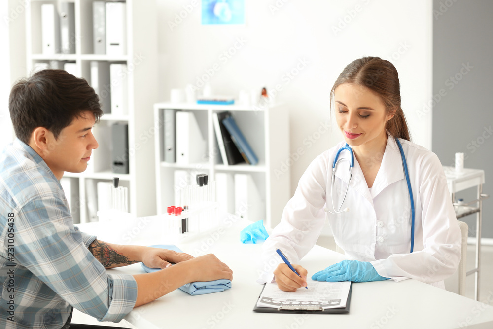 Doctor filling in document before blood draw of patient in hospital Doctor filling in document before blood draw of patient in hospital
