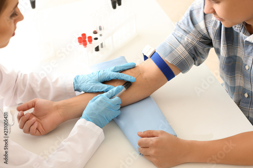 Doctor taking blood sample ...