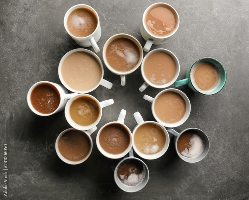 Many cups with tasty aromatic coffee on grey table, flat lay