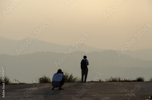 Tourist couple take a sunset on the hill.