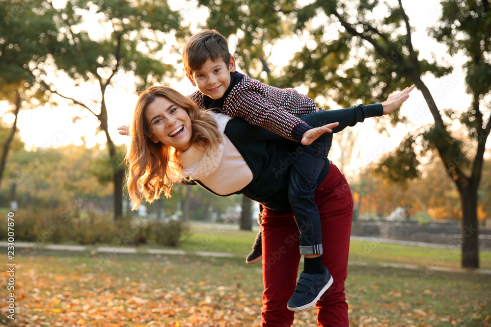 Happy mother and son playing in autumn park Happy mother and son playing in autumn park