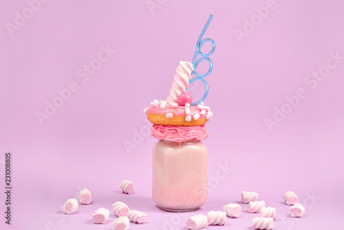 Pink strawberry freakshake with marshmallow and sweets. © Nikolay
