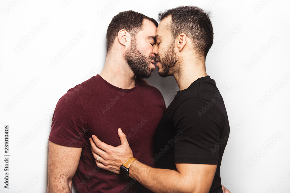 Young homosexuals gay couple love each other on a white background. Young homosexuals gay couple love each other on a white background.