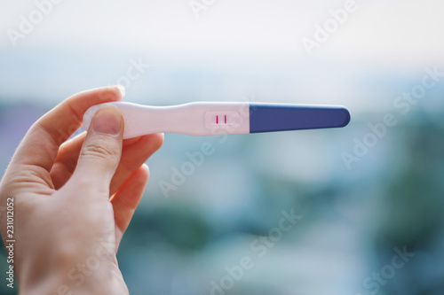 Pregnant woman. Positive test. Two stripes. Test in female hands.